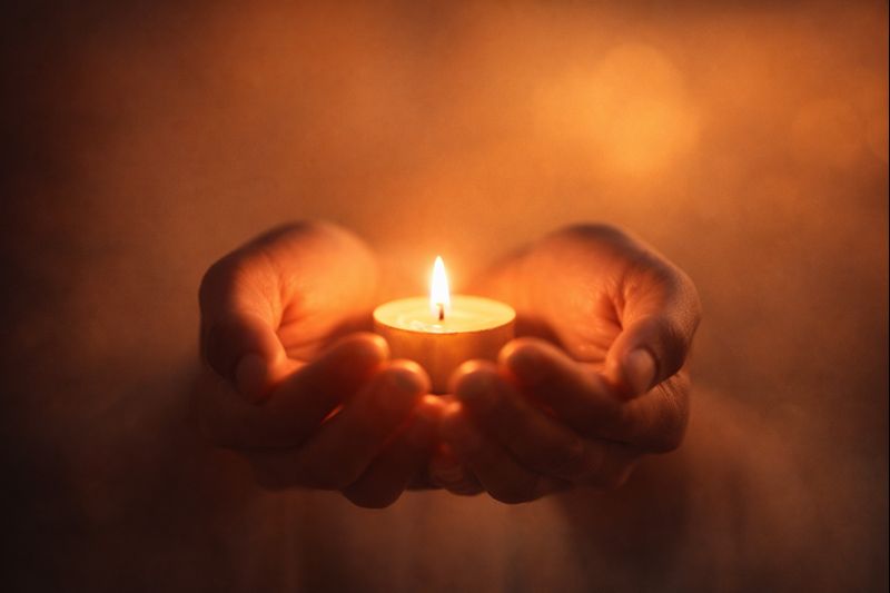 Kaarslicht in handen – rust en nabijheid